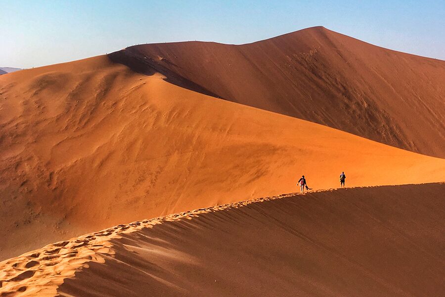 Hiking on sand dunes while on a private, luxury safari tour in Southern Africa with Premier Africa.