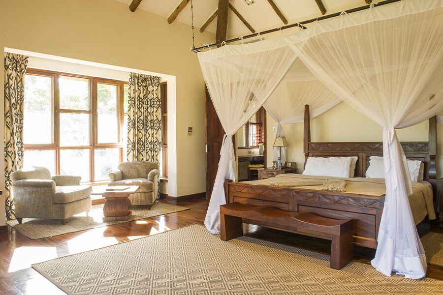 Beautiful luxury accommodation bedroom with king sized bed in Arusha National Park while on a luxury safari tour in Africa