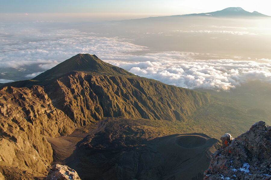 Beautiful scenic view with volcano while trekking through Arusha National Park while on a luxury safari tour.
