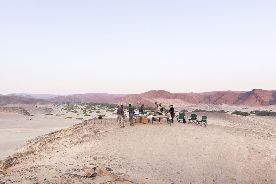 Tour group having sundowners in the desert with stunning view
