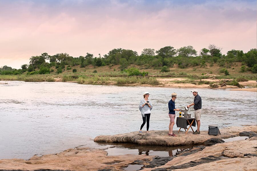 Having drinks at river edge on private safari tour in lion sands, Kruger national park.