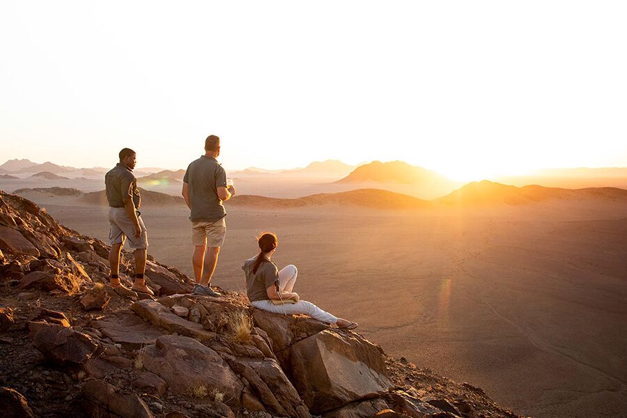 Tourists enjoying sundowners looking over the dunes of the Sossusvlei in Namibia.